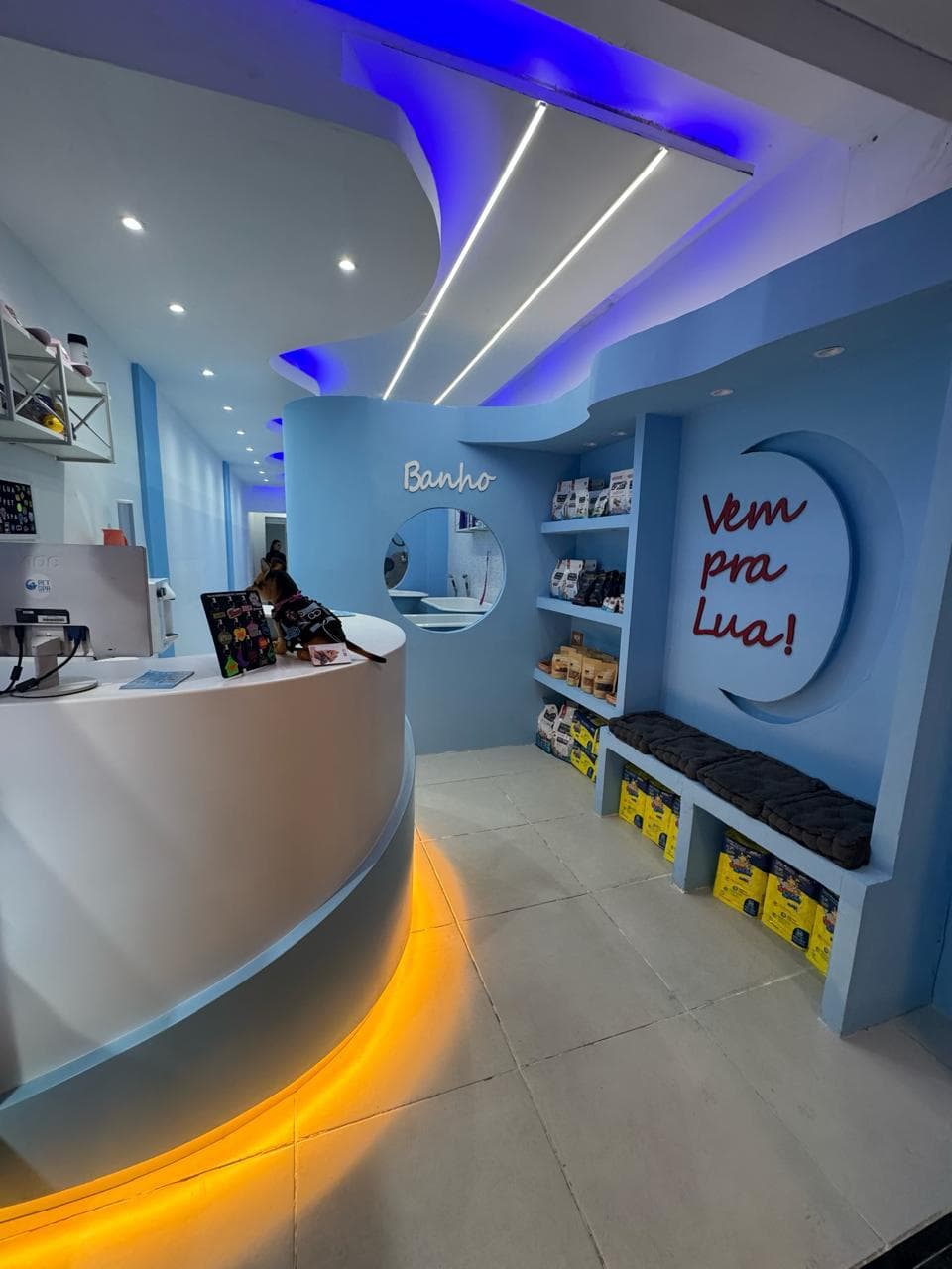 Interior do Lua Pet Spa com o letreiro Vem pra Lua em formato de lua crescente